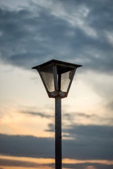 Rustic streetlight with vibrant sunset clouds in Breves, Brazil. Atmospheric evening scene.